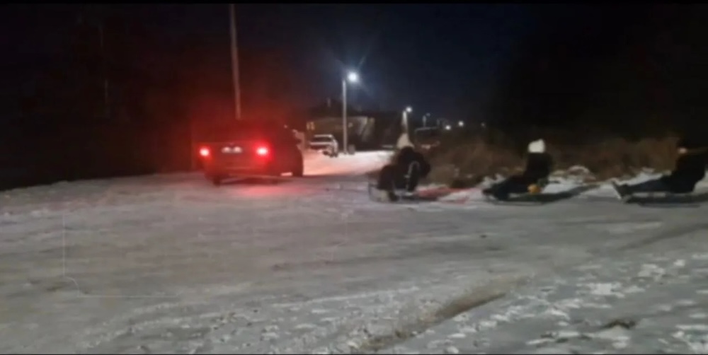 Водитель из Бреста буксирует троих детей на санках. 