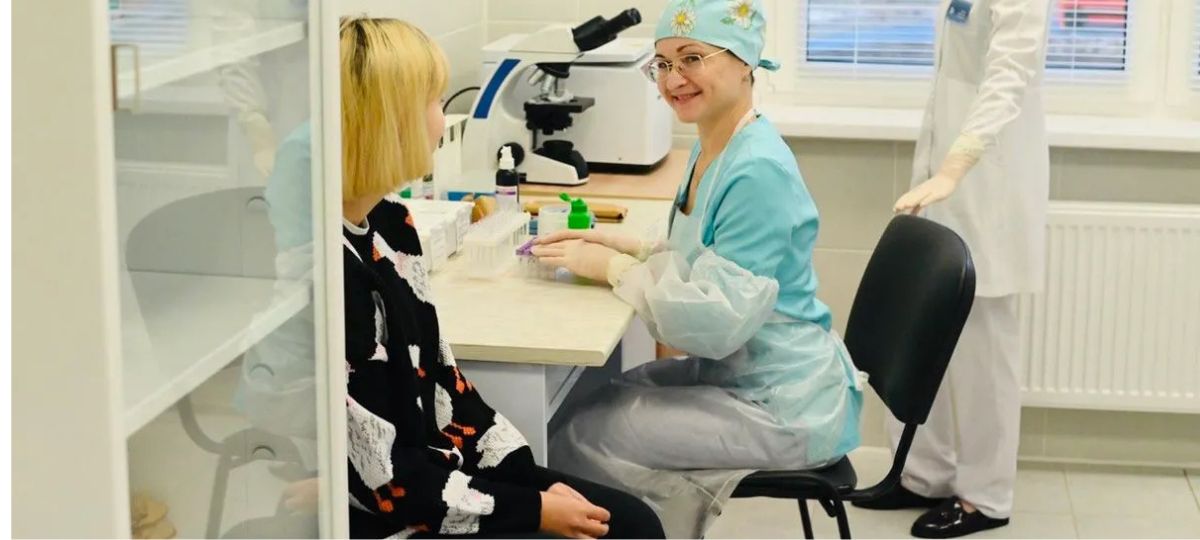 Врач принимает у себя пациента.